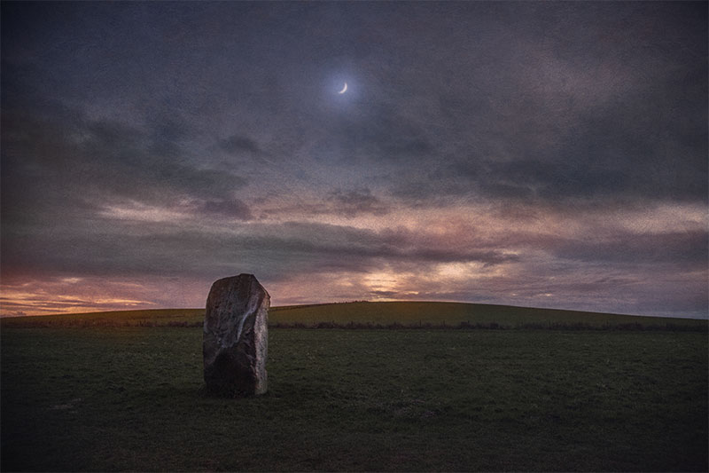 Crescent Moon rising over one of the stones of West Kennet Avenue, Avebury, UK